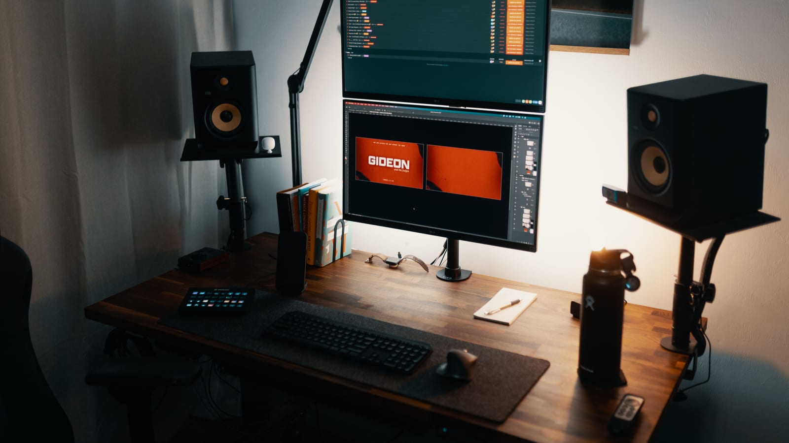 A well-lit modern workspace featuring dual monitors, speakers, and a tidy desk setup.